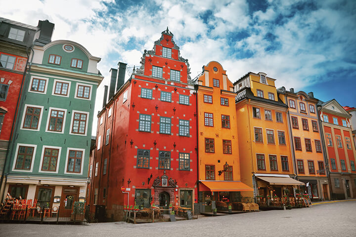 An old town with colorful buildings in a row Go Next